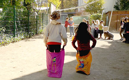 Kinder der DPFA-Regenbogen-Grundschule Leipzig haben Spaß beim Sackhüpfen während des Bewegungstages der Fachschule für Sozialwesen der DPFA Leipzig.